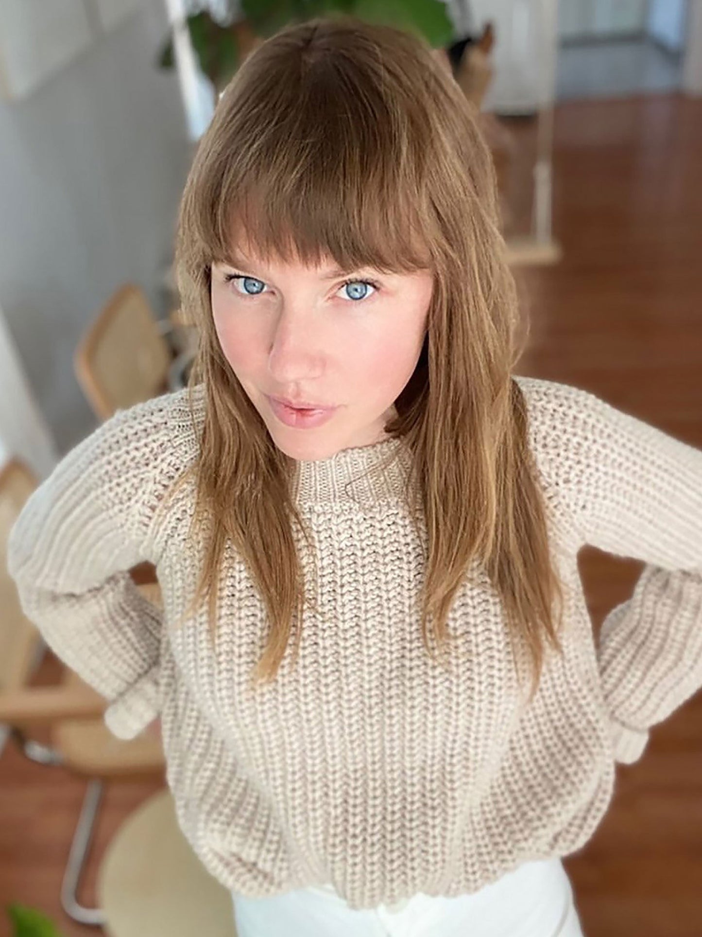 Nui Organics Women's Fishline Sweater in Oatmeal — overhead view of woman in chunky oatmeal merino sweater with white jeans indoors
