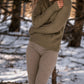 Nui Organics Women's Knit Leggings in Sparrow — woman in sparrow rib knit merino leggings and olive sweater in a snowy winter forest