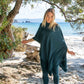 Nui Organics Women's Knit Leggings in Teal — woman wearing teal rib knit merino leggings and matching poncho on a sandy New Zealand beach
