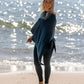 Nui Organics Women's Knit Leggings in Teal — smiling woman in teal merino leggings and poncho standing barefoot on a sunny beach