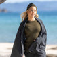 Nui Organics Women's Knit Leggings in Charcoal — woman in charcoal merino leggings, olive knit top and beanie wrapped in a blanket on a sunny beach